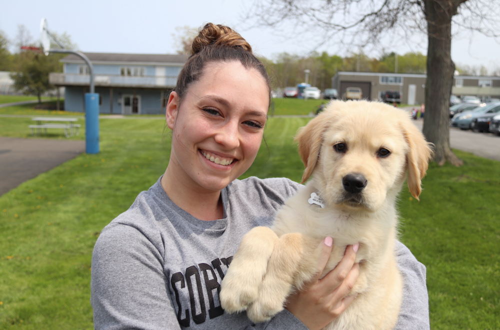 Sarah Cuddeback smiles with her new puppy for the camera 
